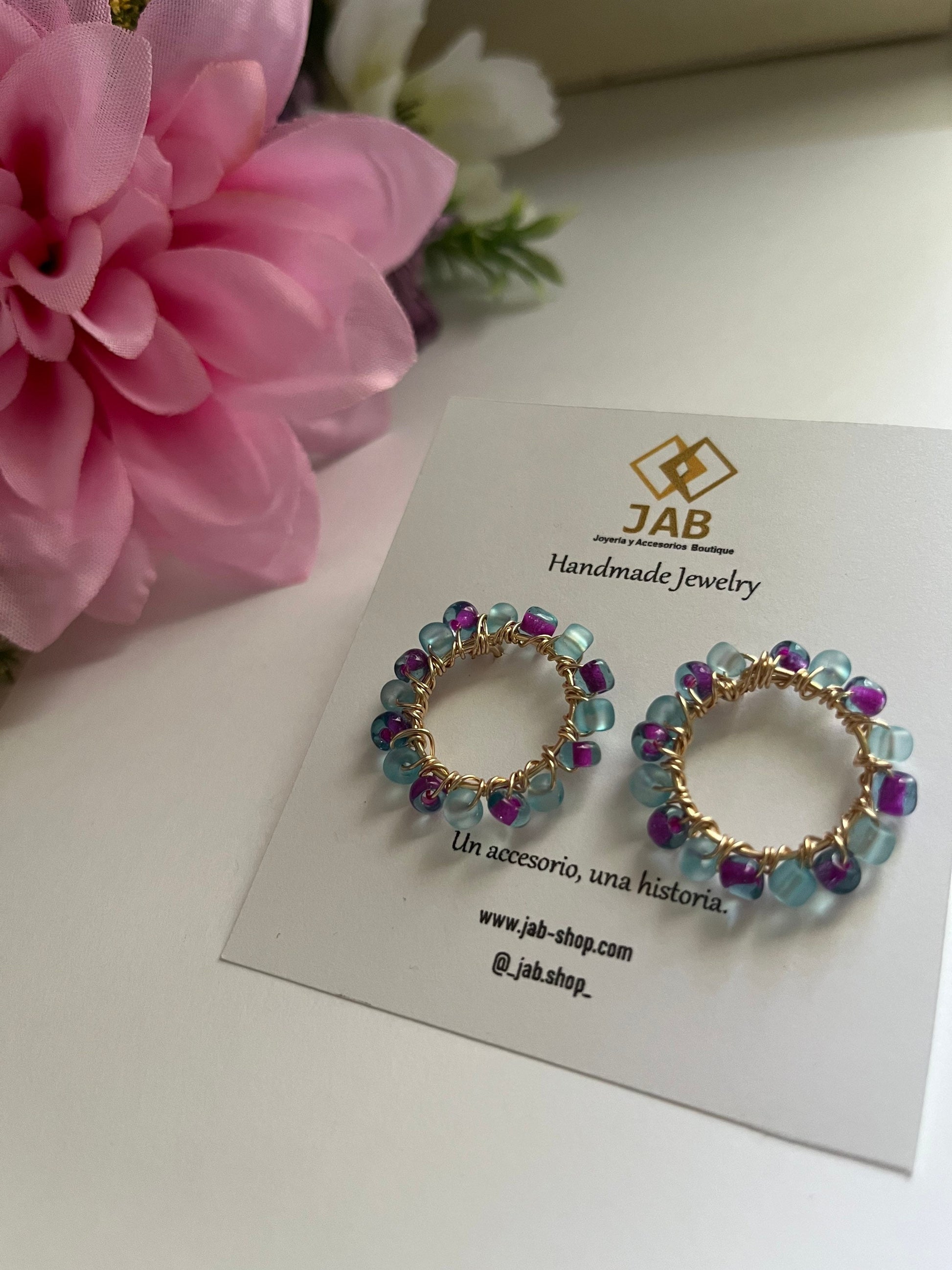 Hypoallergenic circular earrings with multicolored beads.